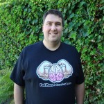 Kevin poses in a Fat Man Unleashed shirt after losing over 50 lbs.